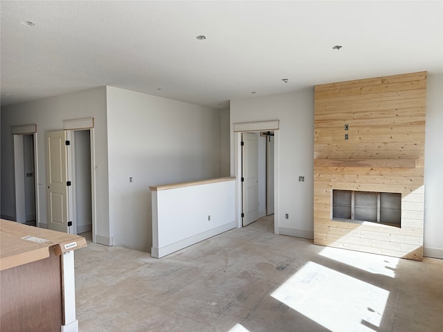 unfurnished living room with a fireplace and baseboards