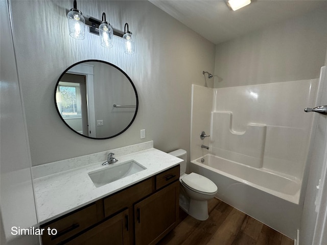 bathroom featuring vanity, shower / bathing tub combination, wood finished floors, and toilet