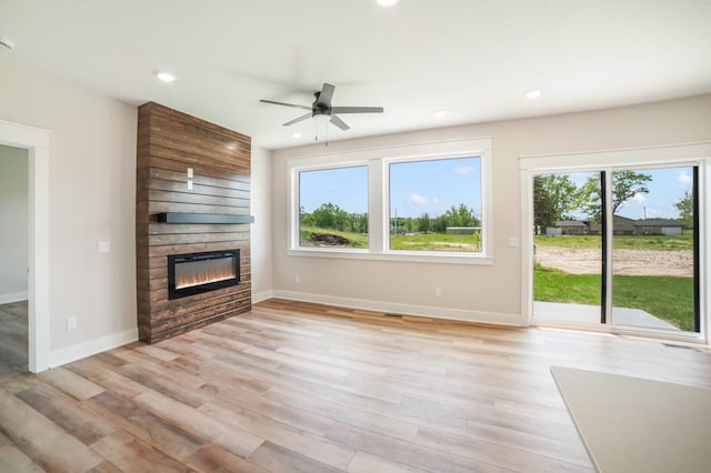 712 Academy Cir, Nevada, IA 50201 - unfurnished living room with a large fireplace, ceiling fan, baseboards, light wood finished floors, and recessed lighting