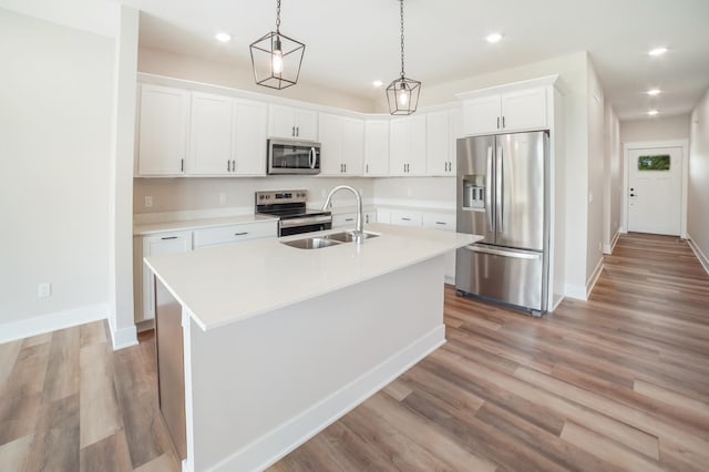 712 Academy Cir, Nevada, IA 50201 - kitchen featuring stainless steel appliances, a sink, baseboards, light wood finished floors, and light countertops