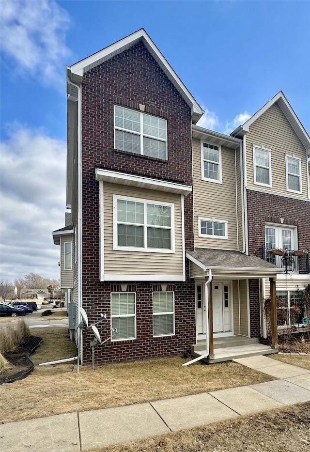 multi unit property featuring a porch and brick siding