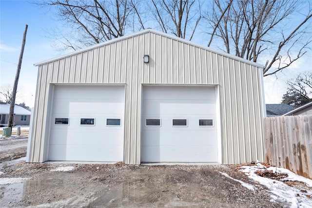 detached garage featuring fence