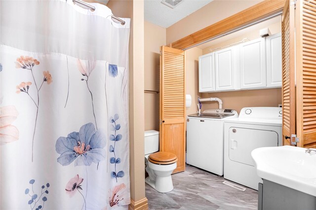 bathroom with visible vents, washer and clothes dryer, toilet, a shower with shower curtain, and vanity