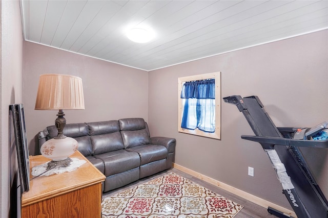 living area with wood finished floors, wood ceiling, and baseboards