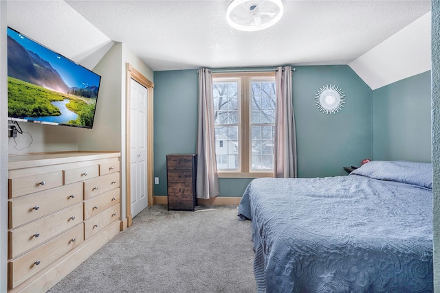 bedroom featuring carpet floors, a textured ceiling, baseboards, and vaulted ceiling