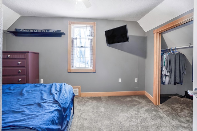 carpeted bedroom featuring visible vents, a ceiling fan, baseboards, a spacious closet, and vaulted ceiling