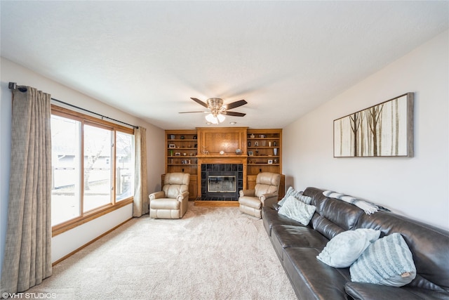 carpeted living room with baseboards, a ceiling fan, and a tile fireplace