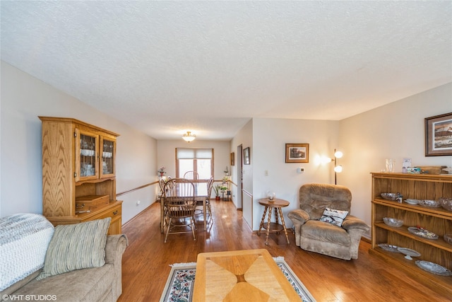 living room with a textured ceiling and wood finished floors