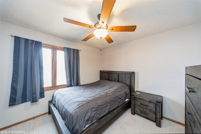 bedroom featuring ceiling fan, baseboards, and light colored carpet