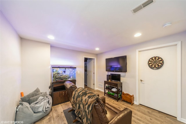 living area with light wood-style flooring, visible vents, baseboards, and recessed lighting