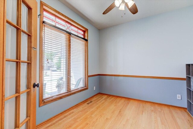 7087 Hillcrest Ct, Johnston, IA 50131 - unfurnished room with wood finished floors, ceiling fan, and baseboards