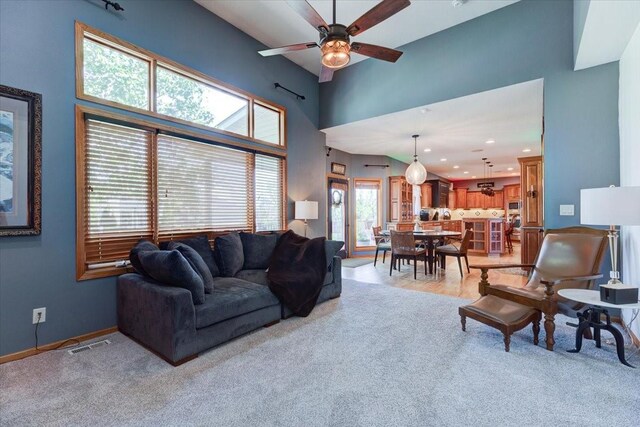 7087 Hillcrest Ct, Johnston, IA 50131 - living room with a ceiling fan, a high ceiling, light carpet, recessed lighting, and baseboards