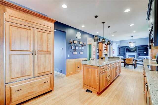 7087 Hillcrest Ct, Johnston, IA 50131 - kitchen featuring open floor plan, ceiling fan, light wood-style floors, black electric cooktop, and light stone countertops