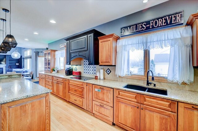 7087 Hillcrest Ct, Johnston, IA 50131 - kitchen with a sink, black electric stovetop, light wood-style flooring, decorative backsplash, and recessed lighting