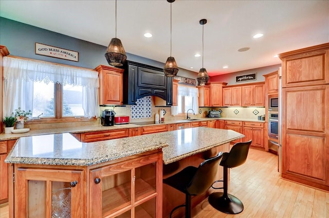 7087 Hillcrest Ct, Johnston, IA 50131 - kitchen featuring appliances with stainless steel finishes, a center island, a warming drawer, light stone countertops, and recessed lighting