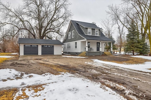 view of front of property featuring a garage, covered porch, and an outbuilding