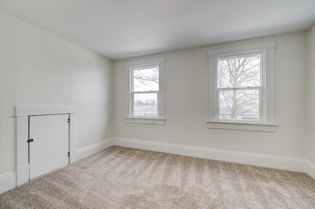 unfurnished room with carpet flooring and baseboards