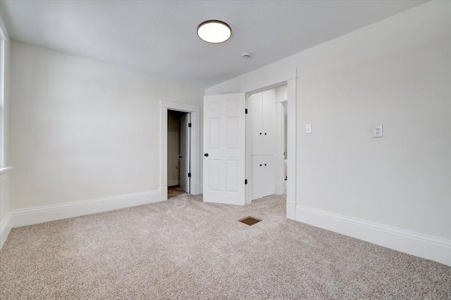 unfurnished room with carpet floors and baseboards