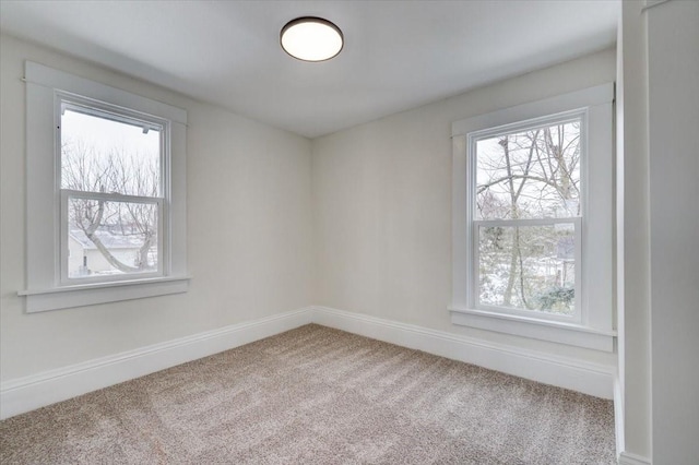 carpeted spare room featuring baseboards