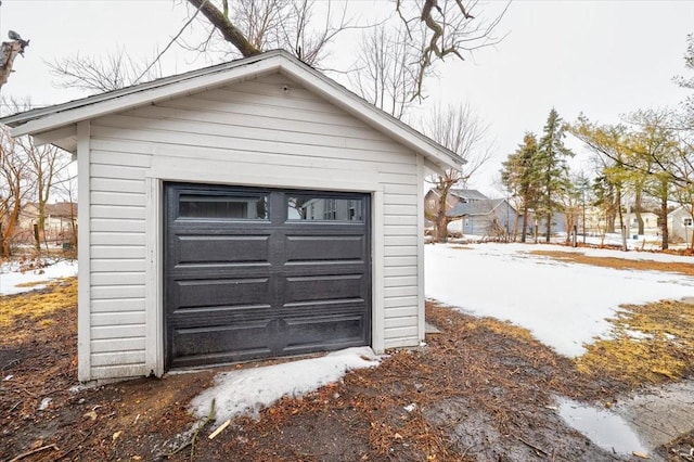 snow covered garage featuring a garage