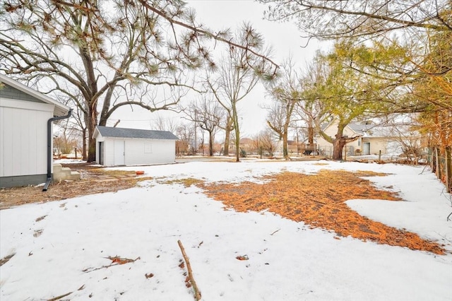 yard covered in snow with an outbuilding