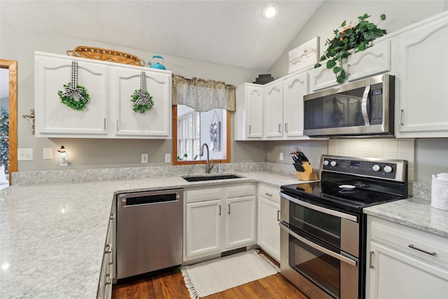 kitchen with stainless steel appliances, white cabinetry, a sink, and dark wood-style floors