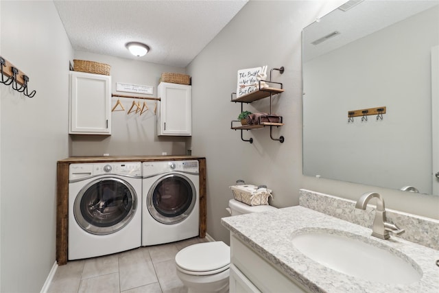 washroom featuring independent washer and dryer, a textured ceiling, a sink, and light tile patterned floors