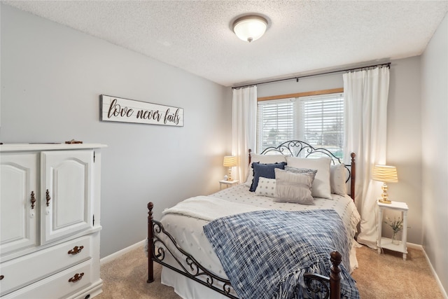 bedroom featuring light carpet, baseboards, and a textured ceiling