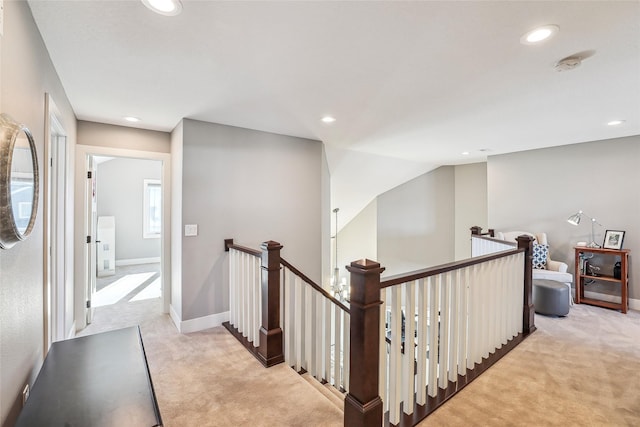 corridor with recessed lighting, an upstairs landing, and light colored carpet