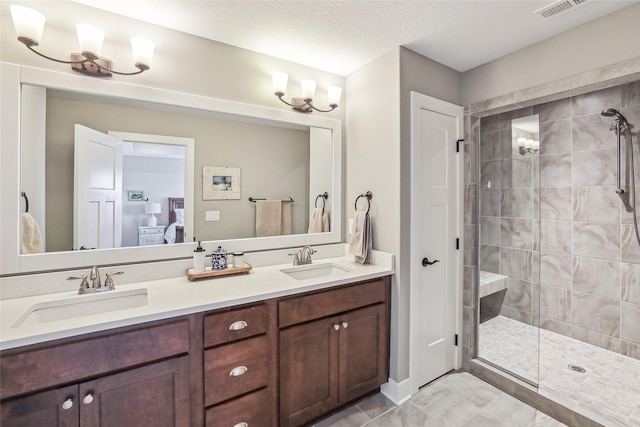 ensuite bathroom with connected bathroom, visible vents, a sink, and tiled shower