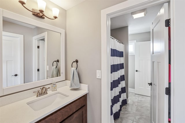 bathroom with a shower with curtain, marble finish floor, and vanity