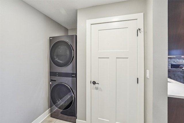 laundry area with stacked washer / dryer, laundry area, and baseboards