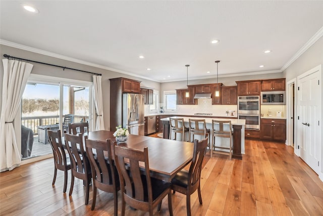 dining area with light wood-style floors, ornamental molding, and recessed lighting