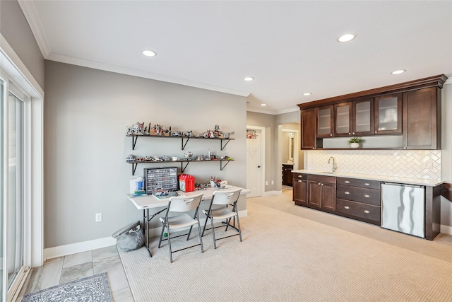 kitchen with dark brown cabinetry, crown molding, decorative backsplash, and a sink