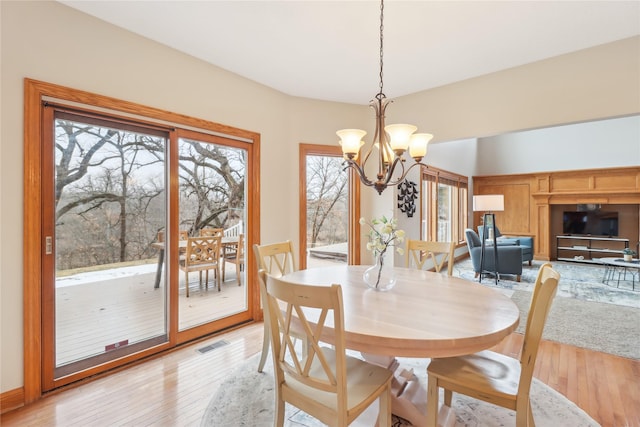 dining space with a chandelier, visible vents, and light wood-style floors