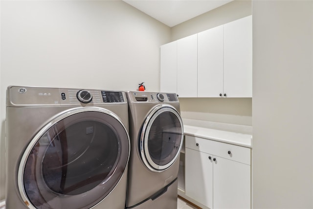 laundry room with cabinet space and washing machine and clothes dryer