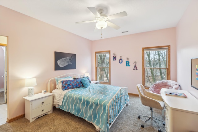 bedroom featuring light carpet, a ceiling fan, and baseboards