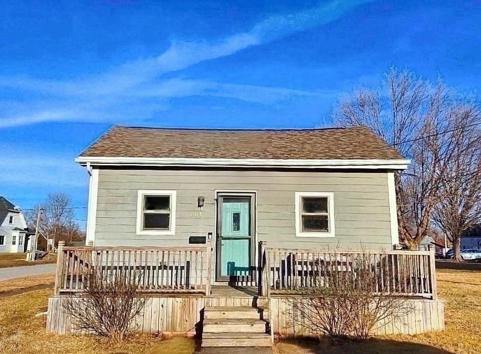 rear view of property featuring a shingled roof and a wooden deck