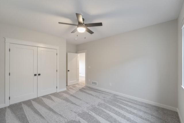 unfurnished bedroom with carpet floors, a ceiling fan, visible vents, baseboards, and a closet