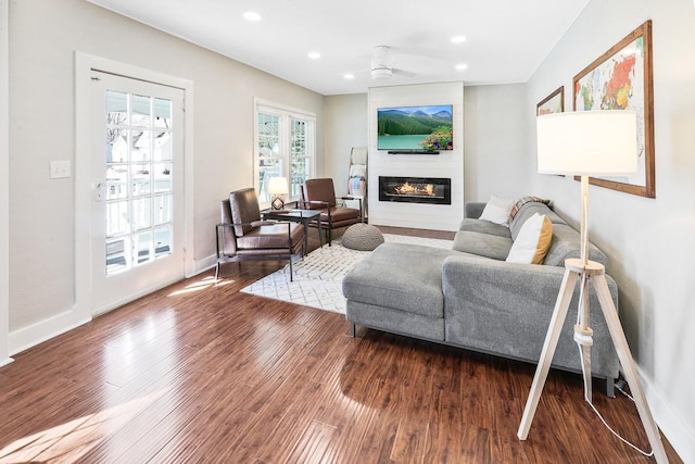 living room with baseboards, a ceiling fan, wood finished floors, a fireplace, and recessed lighting