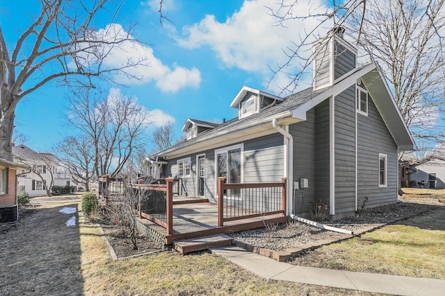 view of home's exterior featuring a chimney and a wooden deck