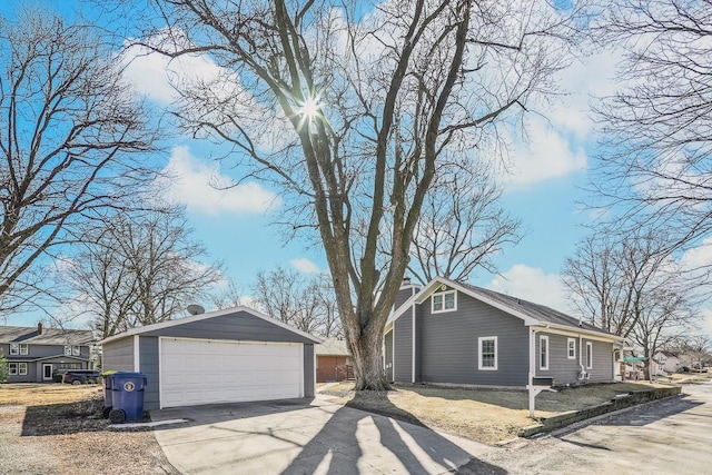 view of side of property featuring an outbuilding, a chimney, and a detached garage