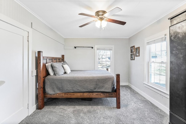 carpeted bedroom featuring ceiling fan, ornamental molding, multiple windows, and baseboards