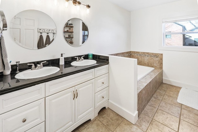 full bath featuring double vanity, tile patterned flooring, a relaxing tiled tub, and a sink