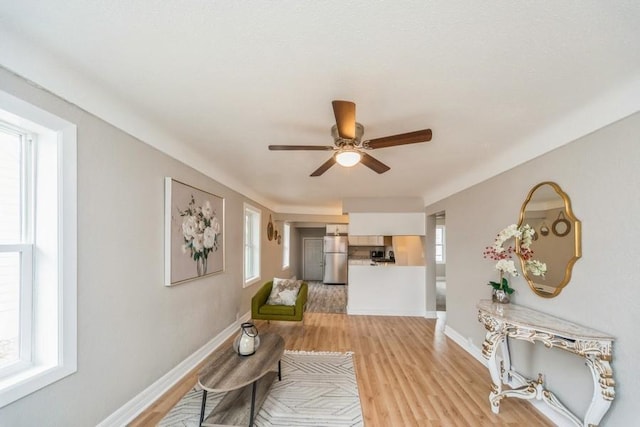 corridor with baseboards and light wood-style floors