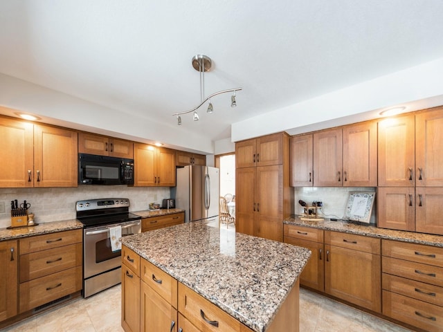 kitchen with tasteful backsplash, appliances with stainless steel finishes, a center island, and brown cabinetry