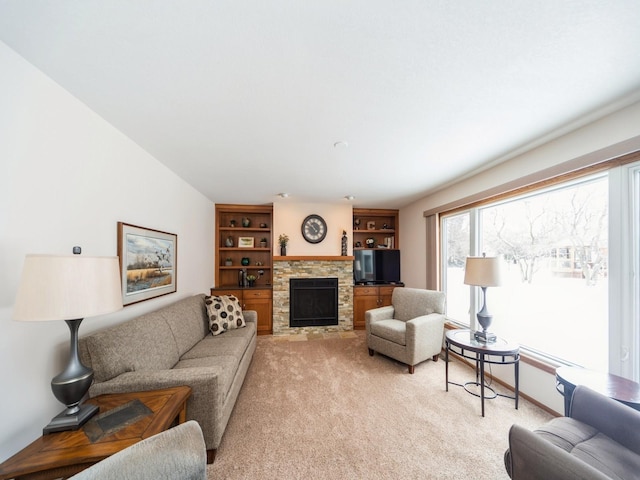 living area with a stone fireplace and light colored carpet