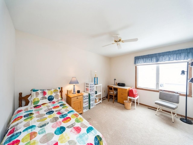 bedroom featuring light carpet, baseboards, and ceiling fan