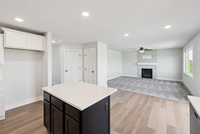 2208 White Oak Ln, Granger, IA 50109 - kitchen featuring a ceiling fan, light wood-style flooring, light countertops, white cabinetry, and baseboards