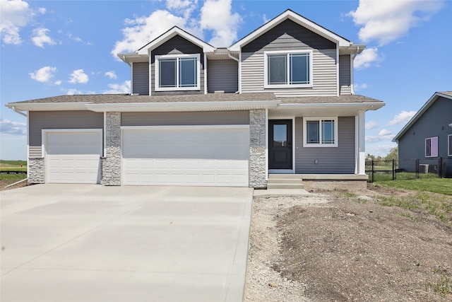 2208 White Oak Ln, Granger, IA 50109 - view of front facade featuring driveway, fence, stone siding, and an attached garage